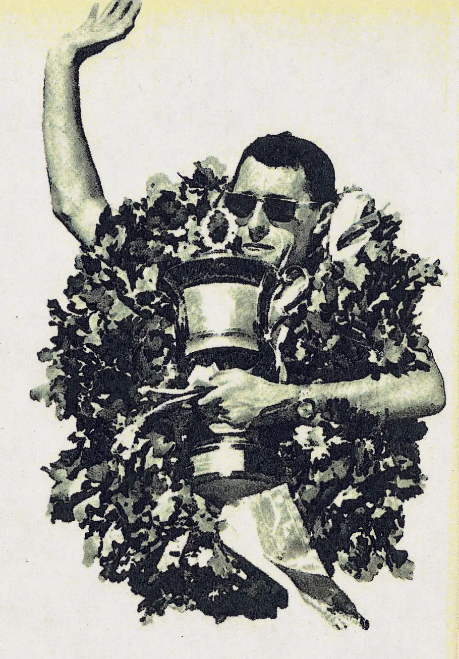 Eine Person mit Sonnenbrille hebt einen Arm und umarmt eine große Trophäe, während sie von einem Blumenkranz umgeben ist.