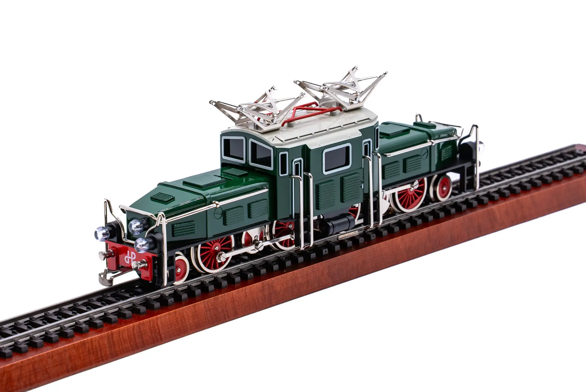 Ein detailliertes Modell einer grün-silbernen Elektrolokomotive mit roten Rädern steht auf einem Ausstellungsgleis mit Holzsockel, fotografiert vor einem weißen Hintergrund.